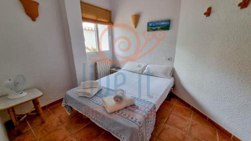 a small bedroom with a bed with two towels on it at CASA BACANA. MORAIRA- LIVE IT COSTABLANCA in Moraira