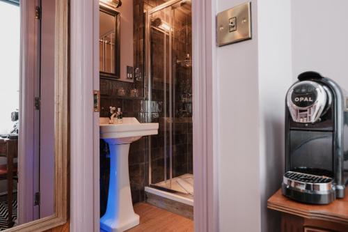 a bathroom with a sink and a shower at The Sanctuary House Hotel in London