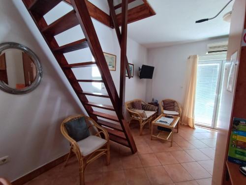 una sala de estar con una escalera de caracol y sillas en Studio Apartmani Zorić, en Šilo