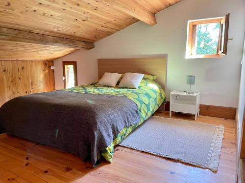 1 dormitorio con cama y techo de madera en Domaine Bourgade, en Betbezer
