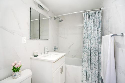 biała łazienka z umywalką i zasłoną prysznicową w obiekcie Gorgeous 2 BR in NYC with Elevator w Nowym Jorku