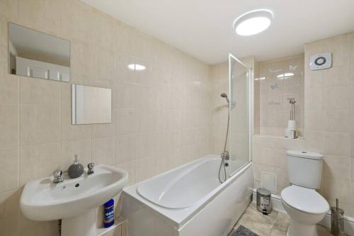 a bathroom with a toilet and a tub and a sink at City Centre, Free Wifi & Netflix in Kent