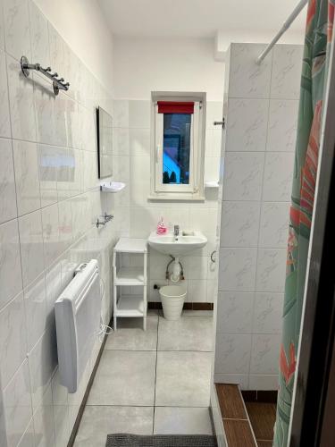 a white bathroom with a sink and a toilet at Posejdon Wydmowa 16-1 in Lubiatowo