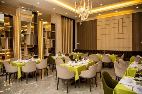 a dining room with tables and chairs and a chandelier at Triple E Hotel and Spa in Addis Ababa