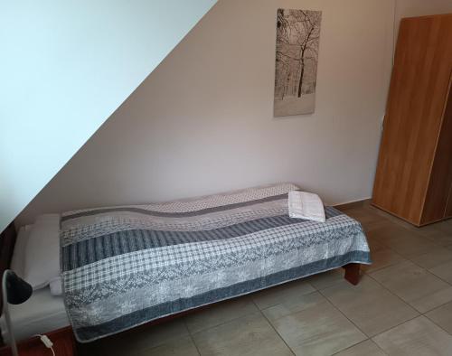 a bed sitting in a room with a staircase at Dom Gościnny Koinonia in Mrągowo