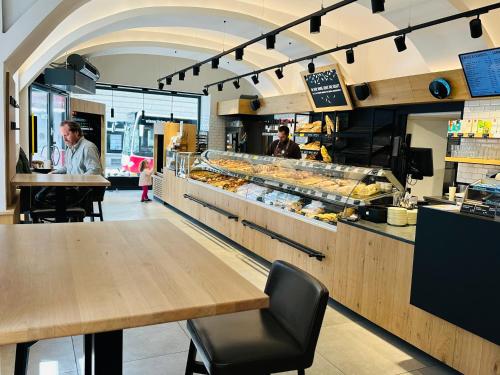 a bakery with two men sitting at tables in front of a counter at Pension Liechtenstein in Vienna