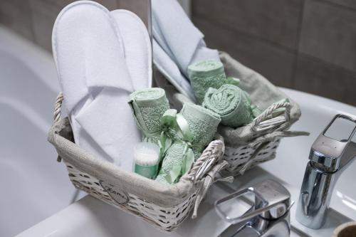 a basket of toiletries sitting on top of a sink at L&R Boutique Apartment in Oţelu Roşu