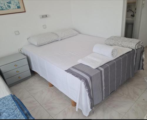 a large bed with white sheets and towels on it at Paradise Studios in Myrtos