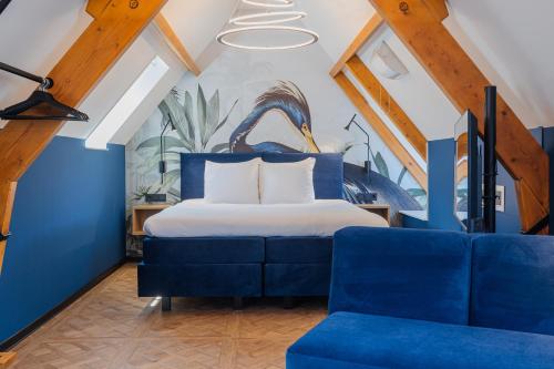 a bedroom with a bed and a blue couch at Hotel St Joris I Kloeg Collection in Middelburg