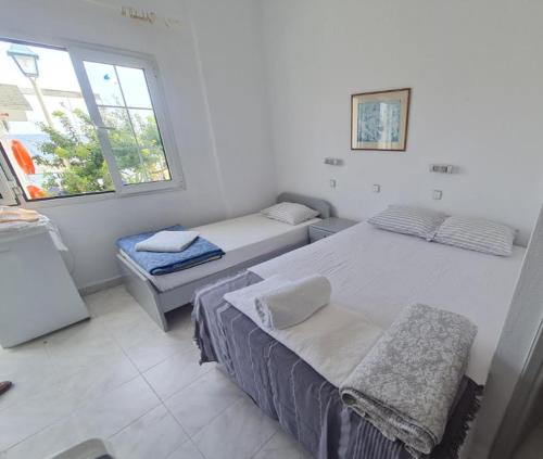a bedroom with two beds and a window at Paradise Studios in Myrtos