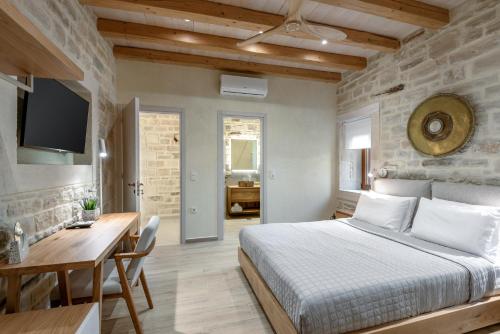 a bedroom with a bed and a table and a desk at Pileas Villa, a Supreme Retreat by the Βeach, By ThinkVilla in Pigianos Kampos