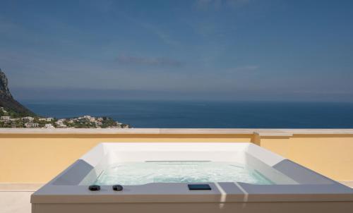 a hot tub on a balcony with a view of the ocean at Palazzo M Capri in Capri