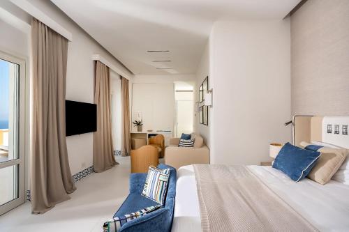 a hotel room with a large bed and a tv at Palazzo M Capri in Capri