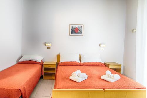 2 Betten mit Handtüchern in einem Schlafzimmer in der Unterkunft Hotel Raimondi in Bellaria-Igea Marina