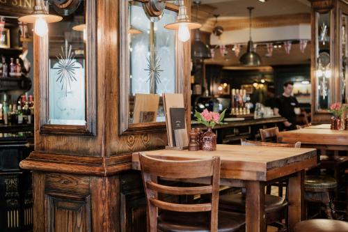 a restaurant with a wooden table and a bar at The Sanctuary House Hotel in London