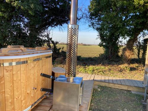 a wood fired stove with a field in the background at Fen meadows glamping - Luxury cabins and Bell tents in Cambridge