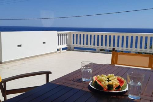 a plate of fruit on a table on a deck at Marirena in Kali Limenes