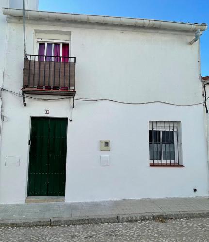 un edificio blanco con una puerta verde y dos ventanas en Casa Cris, en Aracena