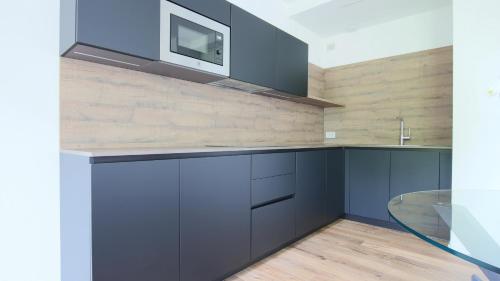 a kitchen with blue cabinets and a glass table at Hotel Corte Santa Libera in San Fedele Intelvi