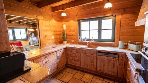 uma grande cozinha com armários de madeira e um lavatório em Ferienhaus Schwarzwaldstern, Todtnau, 3 Schlafzimmer em Todtnau