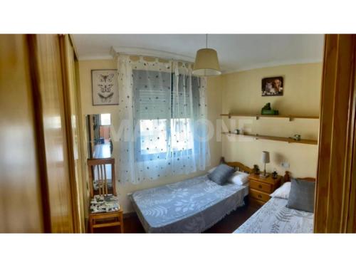 sypialnia z dwoma łóżkami i oknem w obiekcie Apartamento Vacacional A Lanzada w mieście Pontevedra