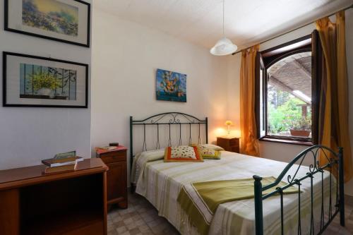 een slaapkamer met een bed, een bureau en een raam bij Salento d a mare in Torre Pali 