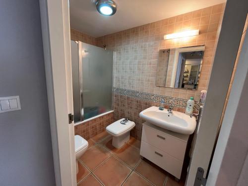 a bathroom with a sink and a toilet and a mirror at Balcón de la Torre del Morche en Torrox Costa in El Morche