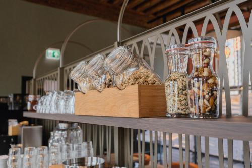 a shelf filled with glasses and bottles on it at Hotel St Joris I Kloeg Collection in Middelburg