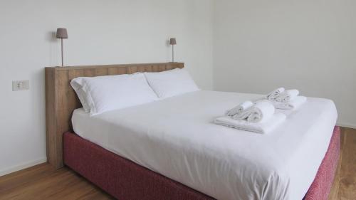a white bed with two towels on top of it at Hotel Corte Santa Libera in San Fedele Intelvi