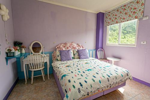 a bedroom with a bed and a table and a chair at 幸福月光民宿 Evening Sun in Green Island