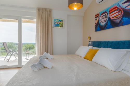 a bedroom with a large white bed with two stuffed animals on it at Villa Bella N in Višnjan
