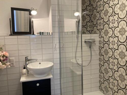 a bathroom with a sink and a glass shower at Ferienwohnung Grete in Münsingen