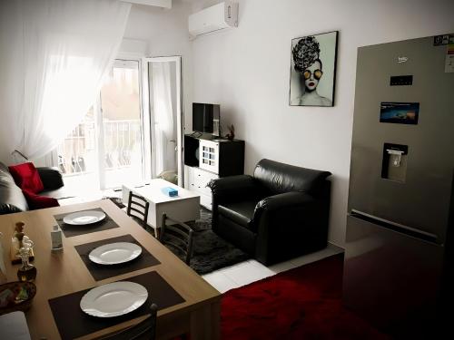 a living room with a table and a couch at Centrally Apartments in Xanthi