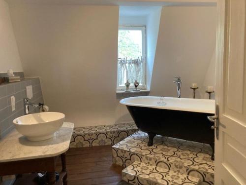 ein Badezimmer mit einer Badewanne und einem Waschbecken in der Unterkunft Ferienwohnung Rahel in Münsingen