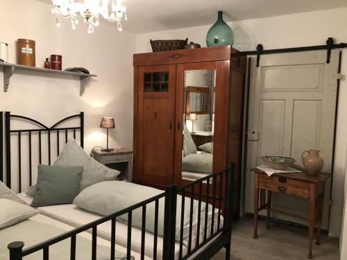 - une chambre avec un lit, une commode et un miroir dans l'établissement Ferienhaus Schillerstraße, à Münsingen