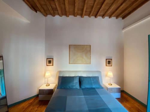 a bedroom with a blue bed and two lamps at Portrait of Livorno in Livorno