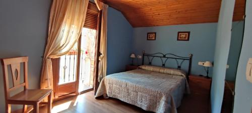 een slaapkamer met een bed en een groot raam bij Casa Cote in Torla