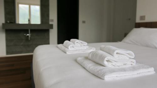 a group of towels sitting on top of a bed at Hotel Corte Santa Libera in San Fedele Intelvi