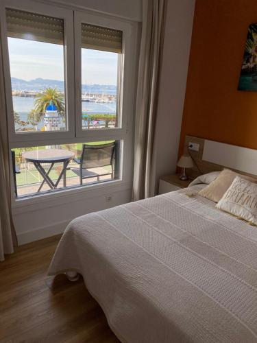 - une chambre avec un lit et une grande fenêtre dans l'établissement Apto. Sanxenxo-Playa, à Sanxenxo