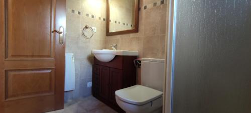een badkamer met een toilet, een wastafel en een spiegel bij Casa Cote in Torla