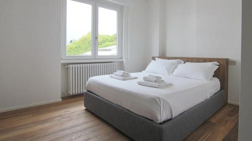 a bedroom with a large bed with two towels on it at Hotel Corte Santa Libera in San Fedele Intelvi