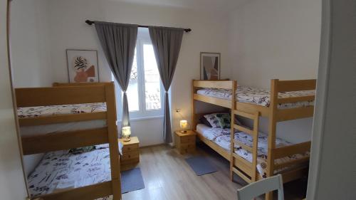 a room with three bunk beds and a window at San Eleuterio Guesthouse in Poreč