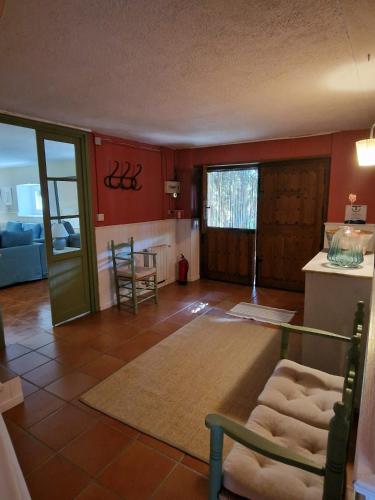 a living room with red walls and a room with a table at Casa Rural Luna in Candeleda