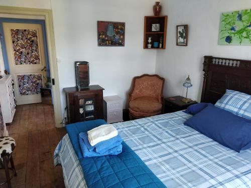 - une chambre avec un lit bleu et une chaise dans l'établissement Cute 1-bed cottage with view across park., à Issac
