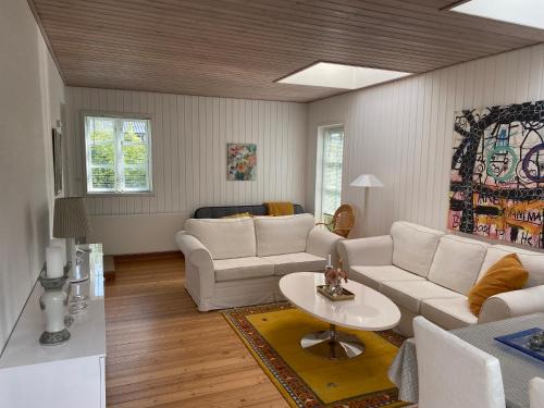 a living room with a white couch and a table at Knasborg Ferieboliger in Ålbæk