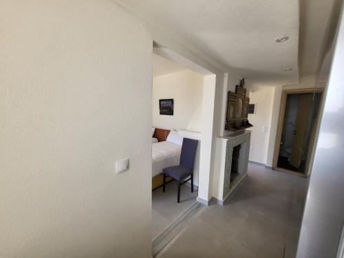 a room with a bed and a chair and a fireplace at Sea & Relax Villa in Sarandë
