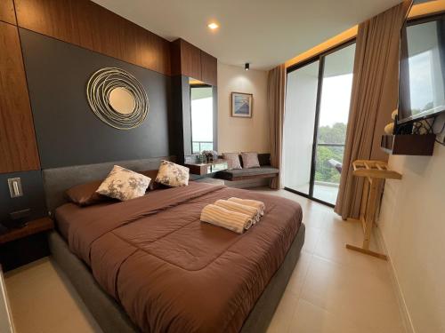 a bedroom with a large bed with a large window at Hi Sea E272 At Escape Condominium Mae Pim Beach in Mae Pim