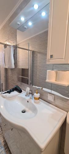 W łazience znajduje się biała umywalka i lustro. w obiekcie Seby Studio w Konstancy