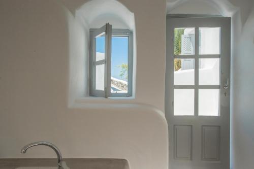 a bathroom with a sink and a window at AQUA SERENITY LUXURY SUITES SANTORINI in Foinikiá