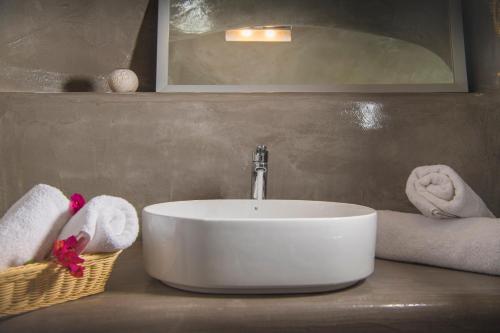 a sink in a bathroom with towels on a counter at AQUA SERENITY LUXURY SUITES SANTORINI in Foinikiá
